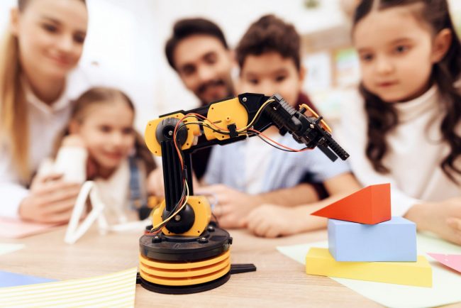 The children are looking at the robot.