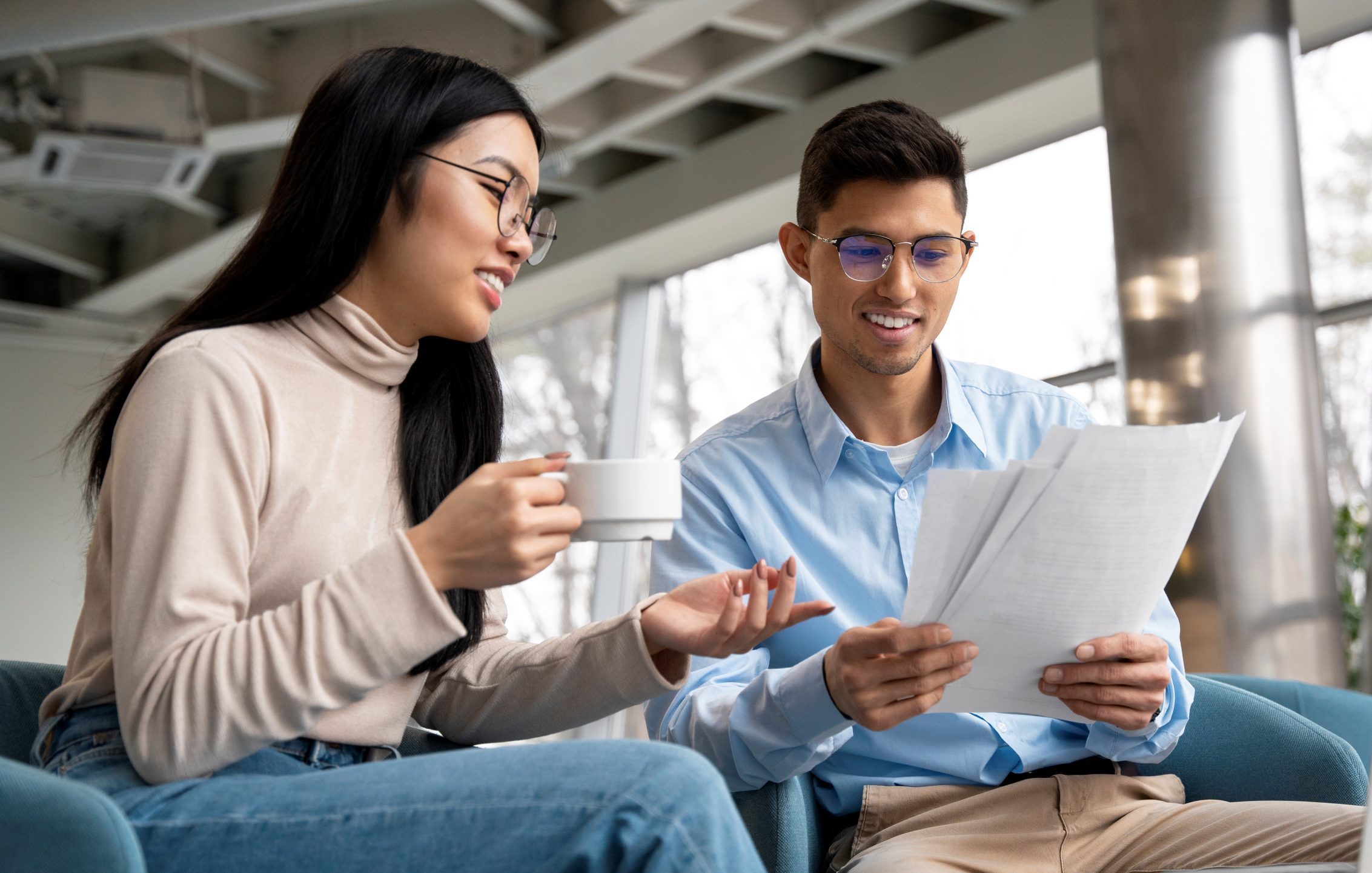 Woman and man talking while looking at papers.