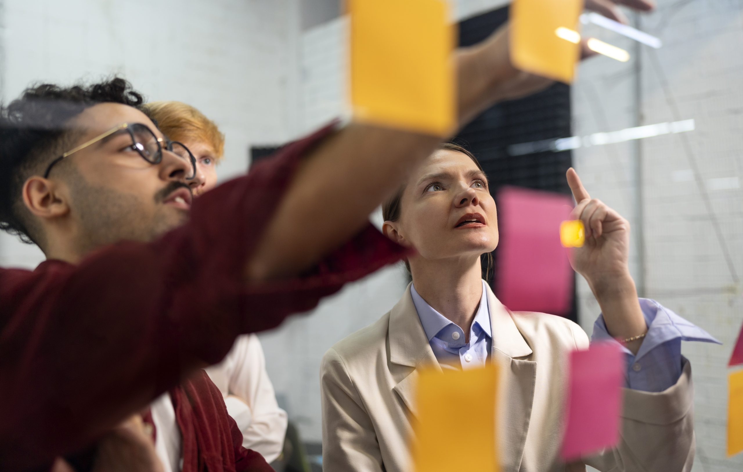 Team looking at clear wall wit post its.