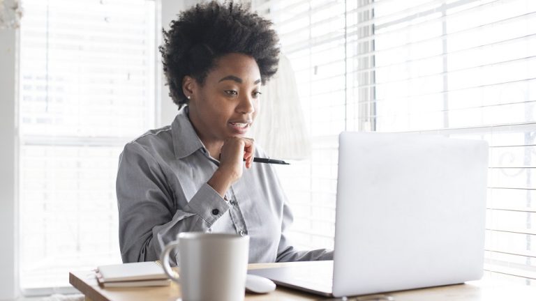 Woman looking at computer illustrates blog "Is Project Management Related to Computer Science?"