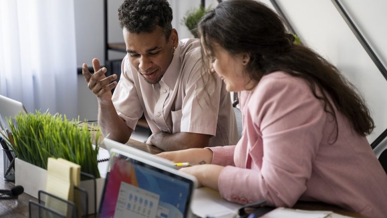 Man and woman working in office illustrate blog "What a Project Manager Should NOT Do?"