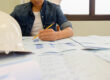 Engineering design specialist reviewing blueprints in California